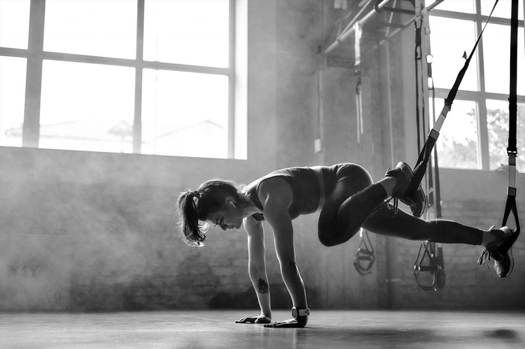 Athlete training with suspension straps in the gym